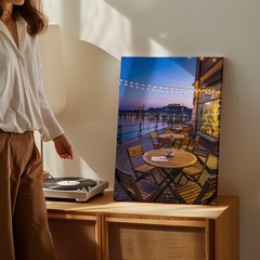 Cozy Outdoor Café Scene At Dusk, Featuring A Round Wooden Wall Art Canvas Print